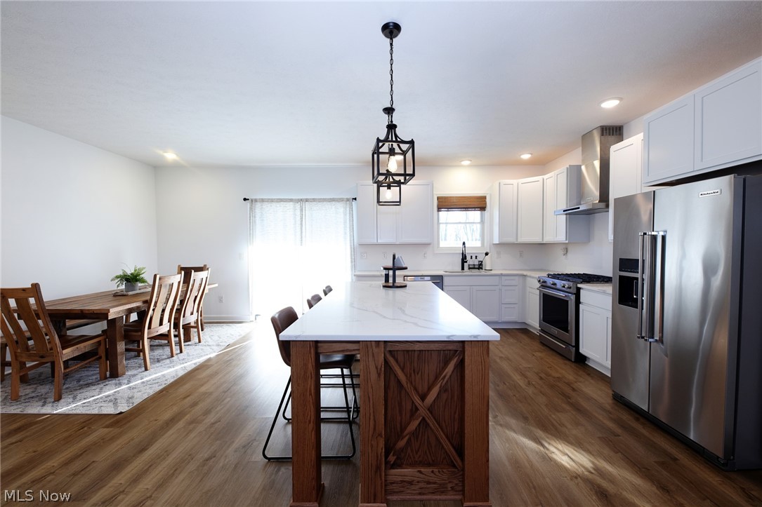 258 Friendly Acres Road Wellsburg, WV 26070 - Photo 6 of 47 Eat-In Kitchen featuring stainless steel appliances, white cabinetry, wood-style floors, and a kitchen island