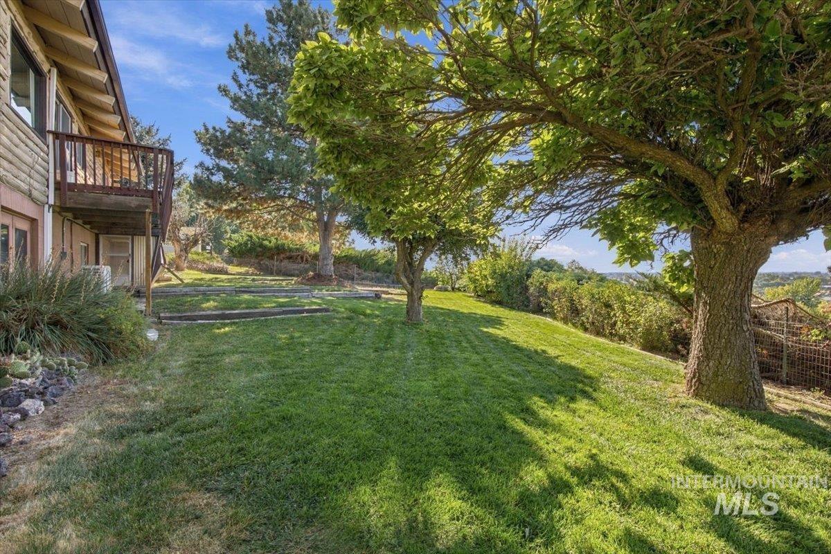 10201 Willis Road Middleton, ID 83644 - Photo 37 of 38 Expansive sloped lawn with mature trees and a wood deck