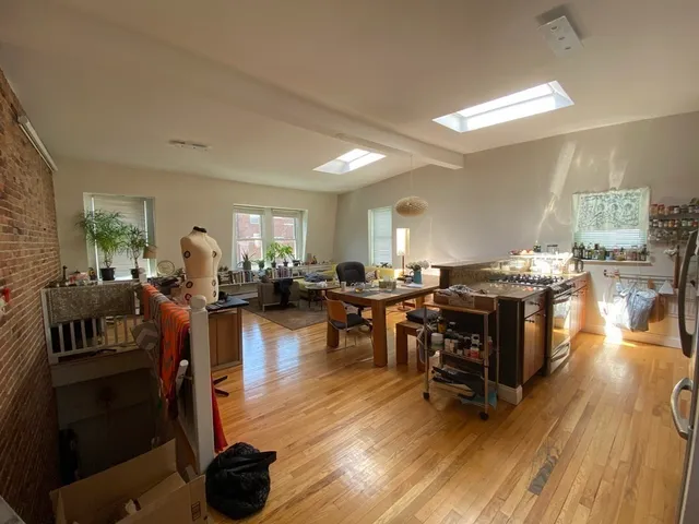 a living room with furniture a wooden floor and a sink