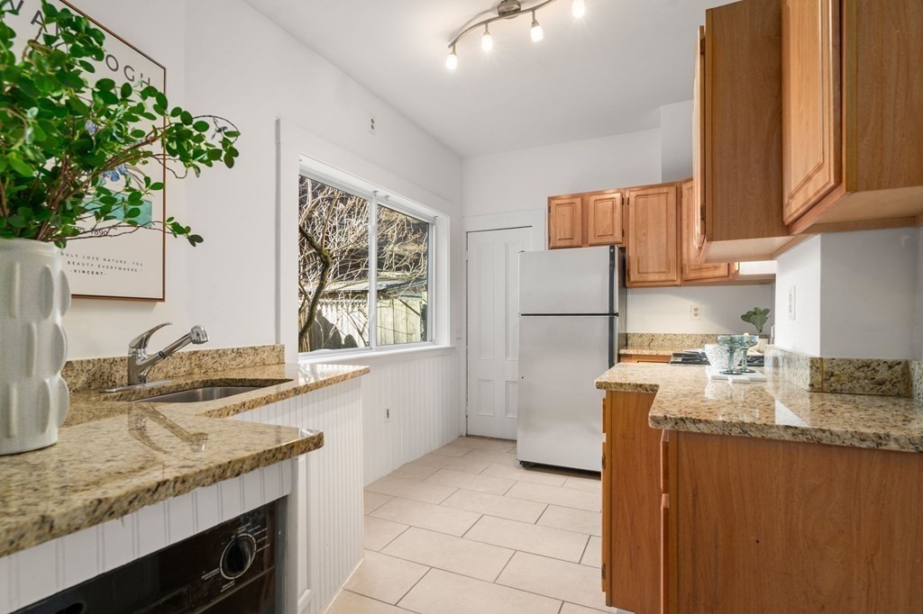 110 Elm Street, Unit 1 Boston, MA 02129 - Photo 11 of 17 a kitchen with granite countertop a sink a stove and a wooden floor