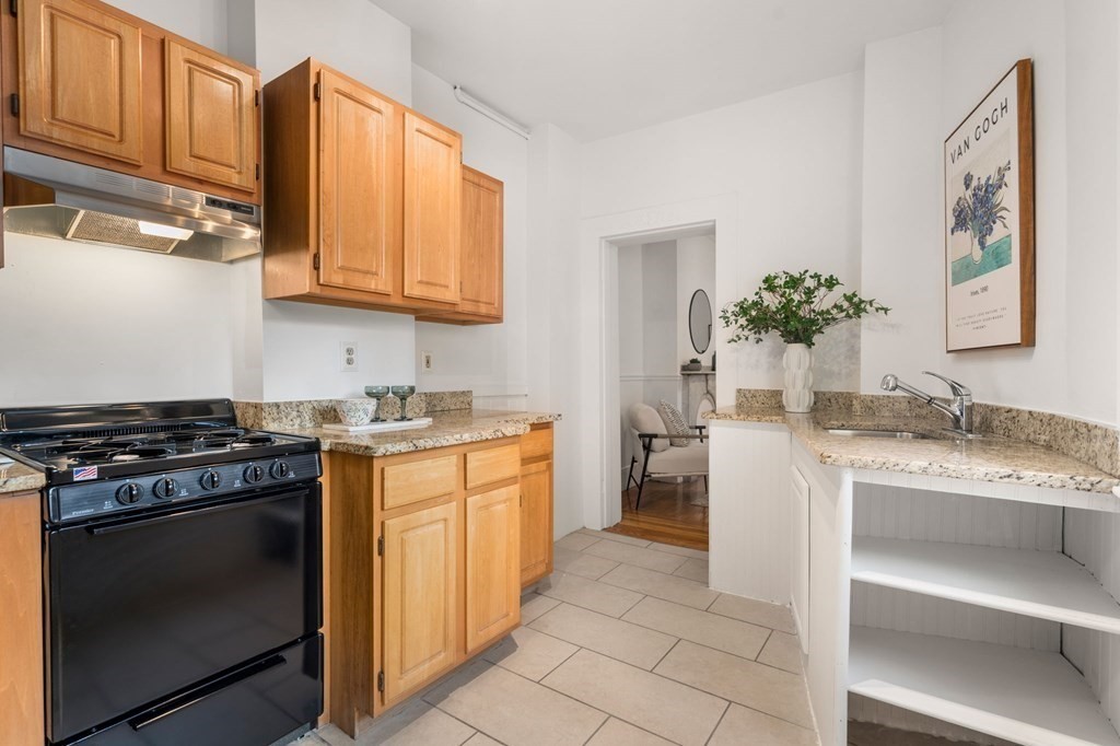 110 Elm Street, Unit 1 Boston, MA 02129 - Photo 12 of 17 a kitchen with stainless steel appliances granite countertop a stove a sink and a microwave