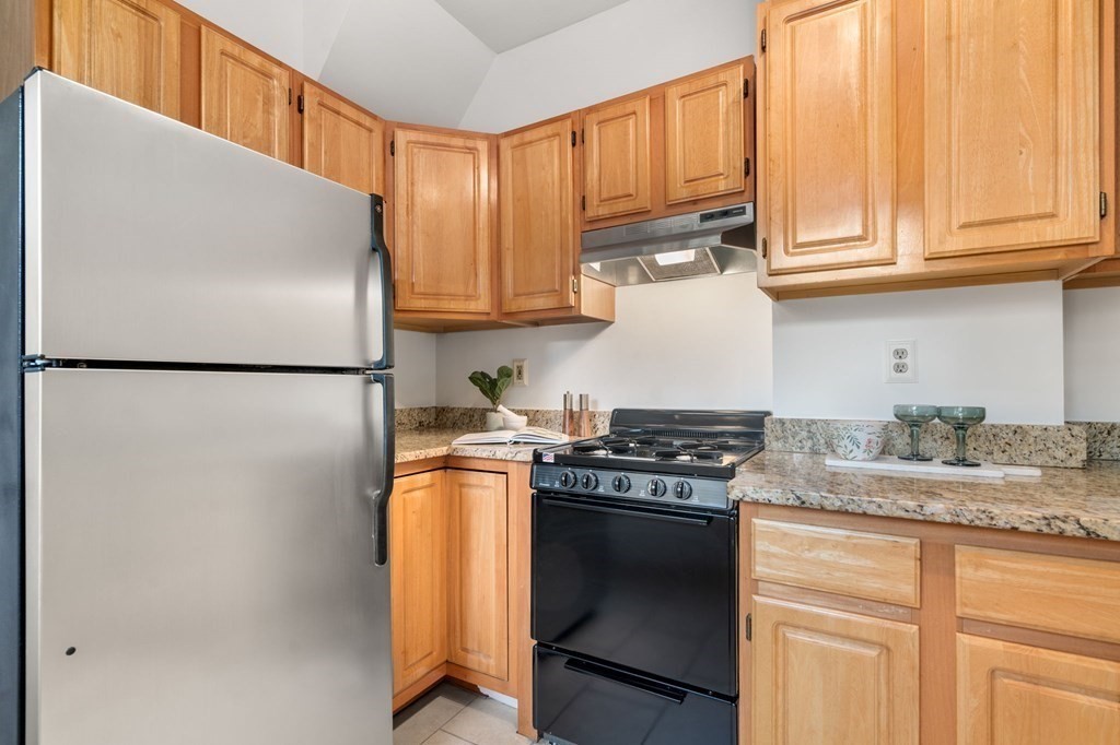 110 Elm Street, Unit 1 Boston, MA 02129 - Photo 13 of 17 a kitchen with stainless steel appliances granite countertop a refrigerator sink stove and cabinets