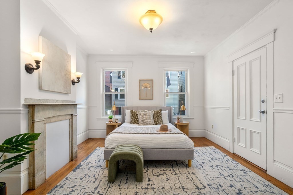 110 Elm Street, Unit 1 Boston, MA 02129 - Photo 7 of 17 a bedroom with a bed and a chandelier