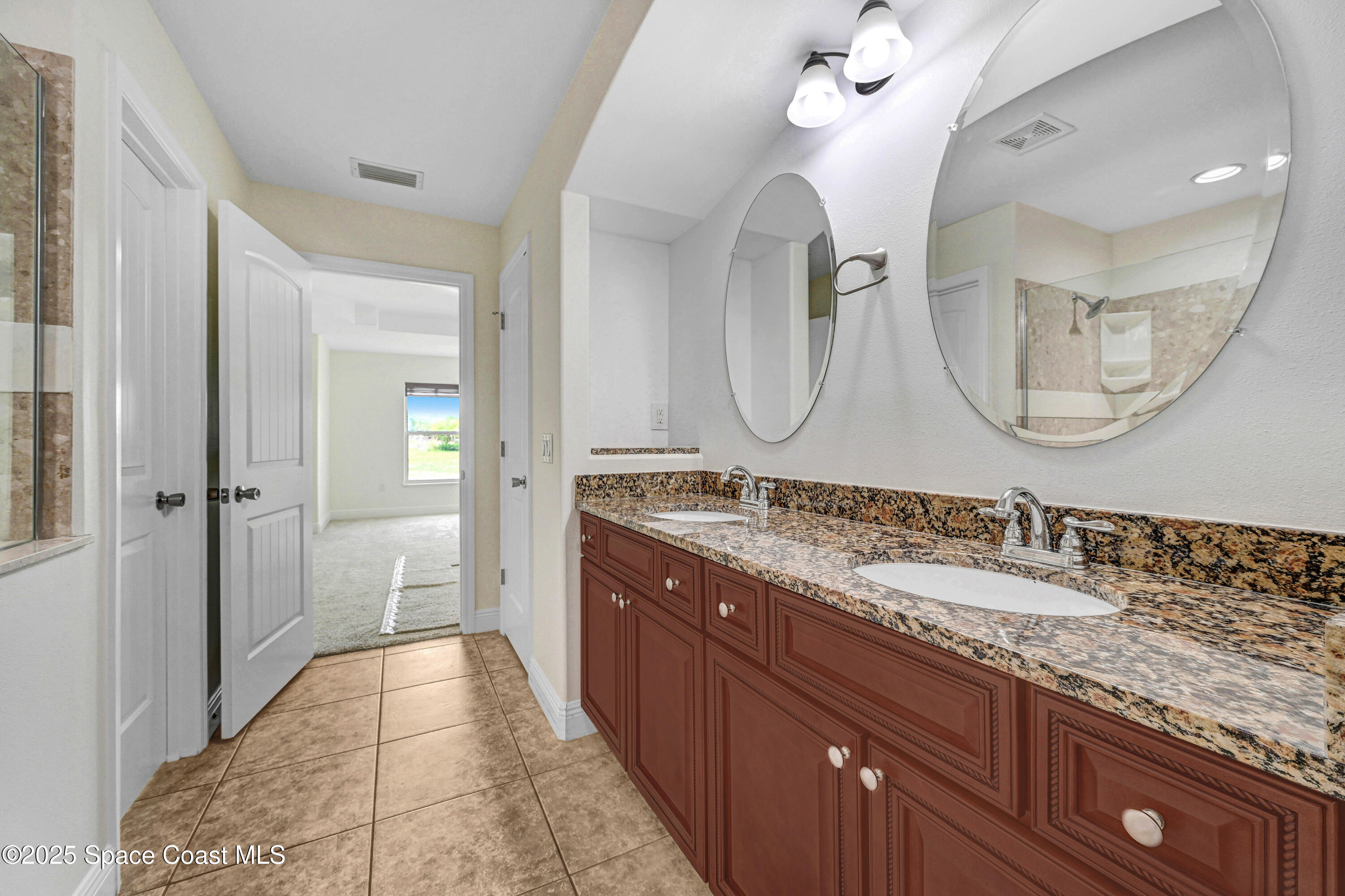 4031 Brantley Circle Rockledge, FL 32955 - Photo 17 of 41 a spacious bathroom with a granite countertop double vanity sink mirror and