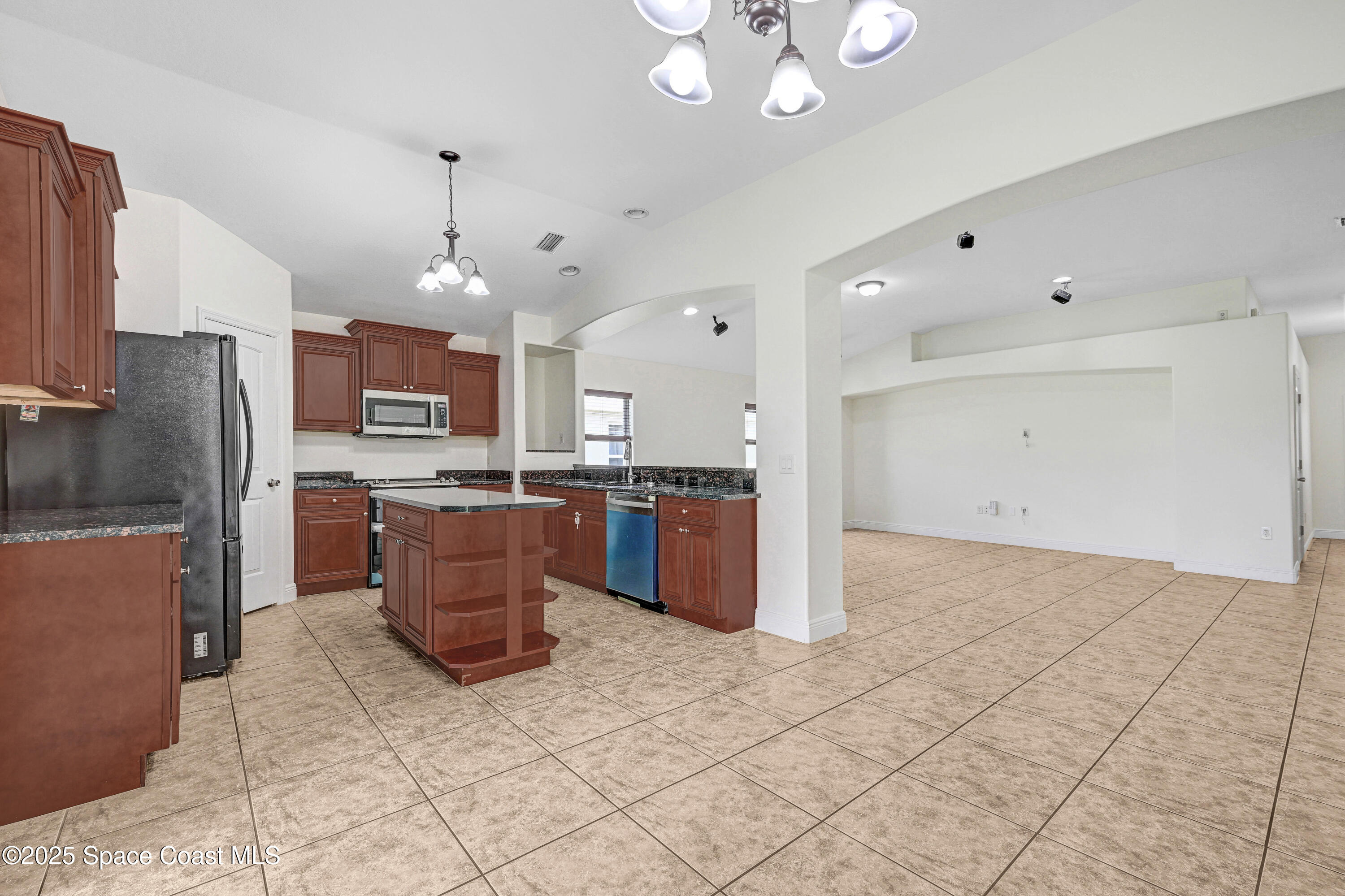 4031 Brantley Circle Rockledge, FL 32955 - Photo 33 of 41 a kitchen with stainless steel appliances kitchen island granite countertop a refrigerator a stove a sink a microwave and island
