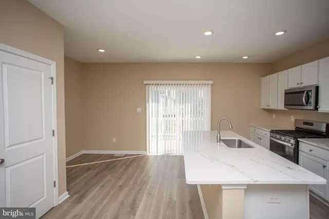 a kitchen with a sink and wooden floor