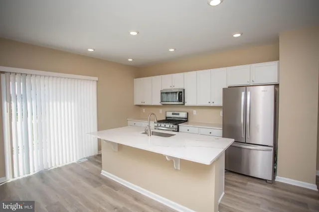 a view of an empty room with wooden floor and closet