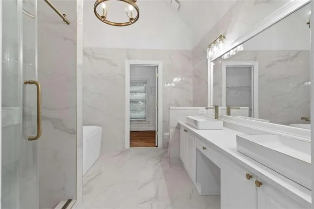 a spacious bathroom with a granite countertop sink mirror and bathtub
