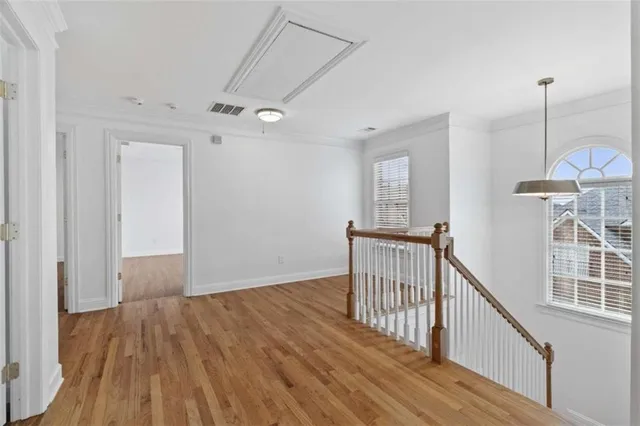 a view of a hallway with wooden floor and staircase