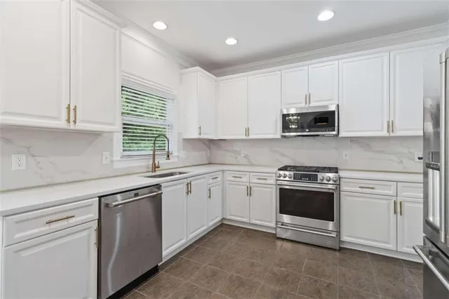 a kitchen with stainless steel appliances granite countertop a sink a stove a microwave and cabinets
