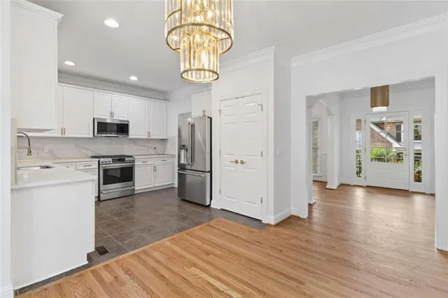 a kitchen with stainless steel appliances granite countertop a refrigerator and a stove top oven