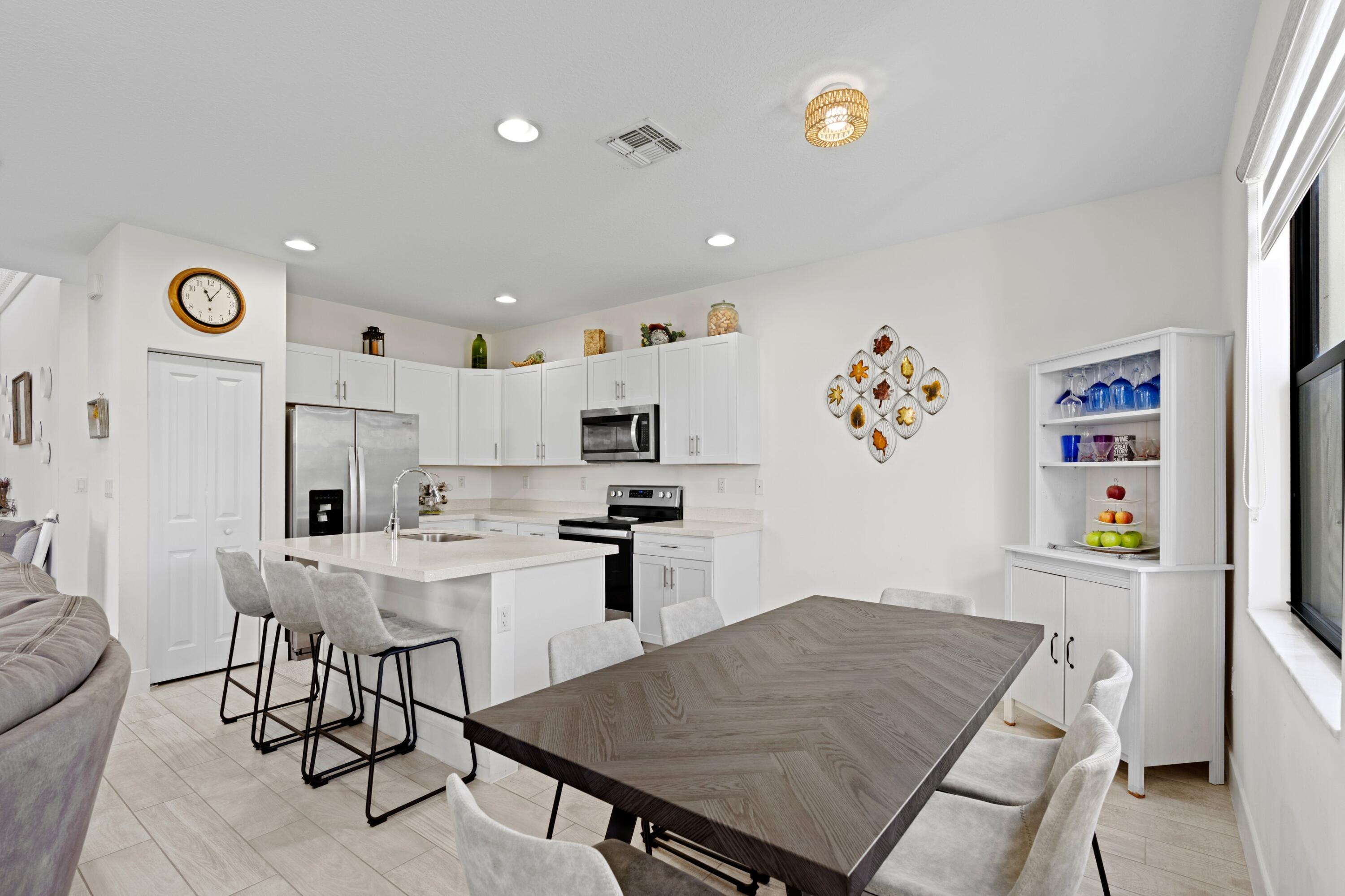 4021 Sycamore Cove Riviera Beach, FL 33410 - Photo 13 of 37 a kitchen with stainless steel appliances granite countertop a refrigerator and a stove top oven