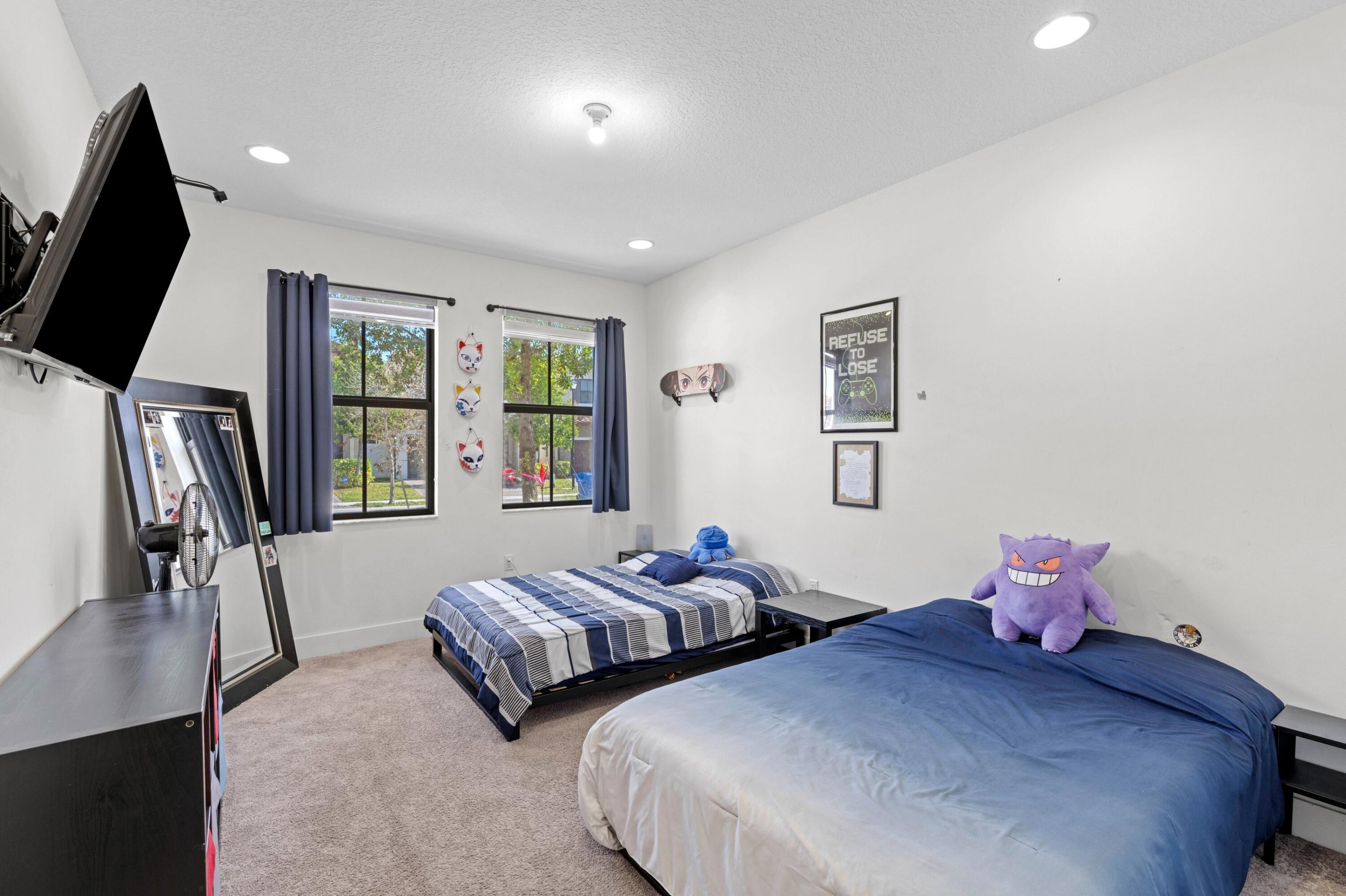 4021 Sycamore Cove Riviera Beach, FL 33410 - Photo 17 of 37 a bedroom with two beds and a flat screen tv