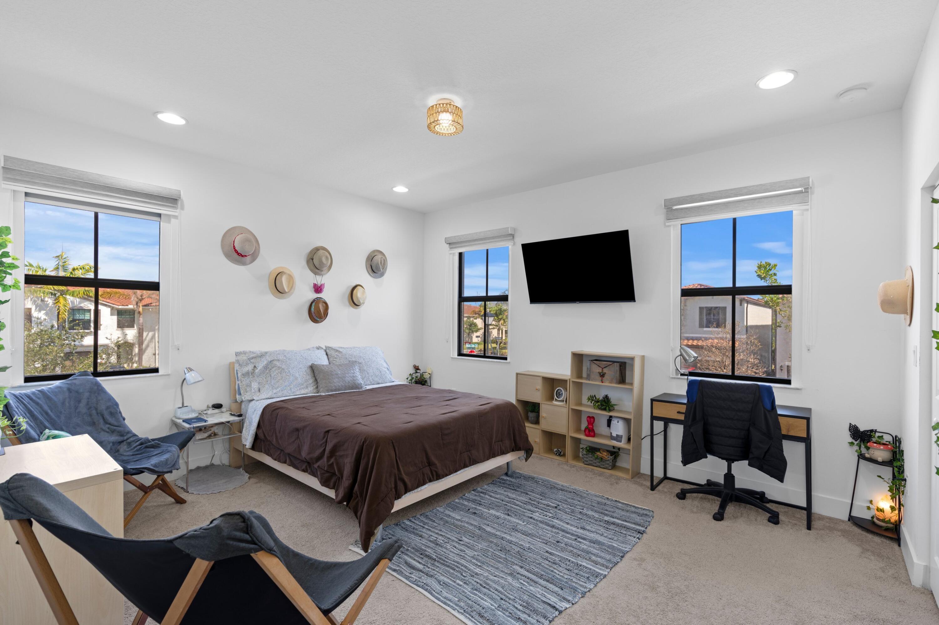 4021 Sycamore Cove Riviera Beach, FL 33410 - Photo 20 of 37 a bedroom with a bed and a flat screen tv