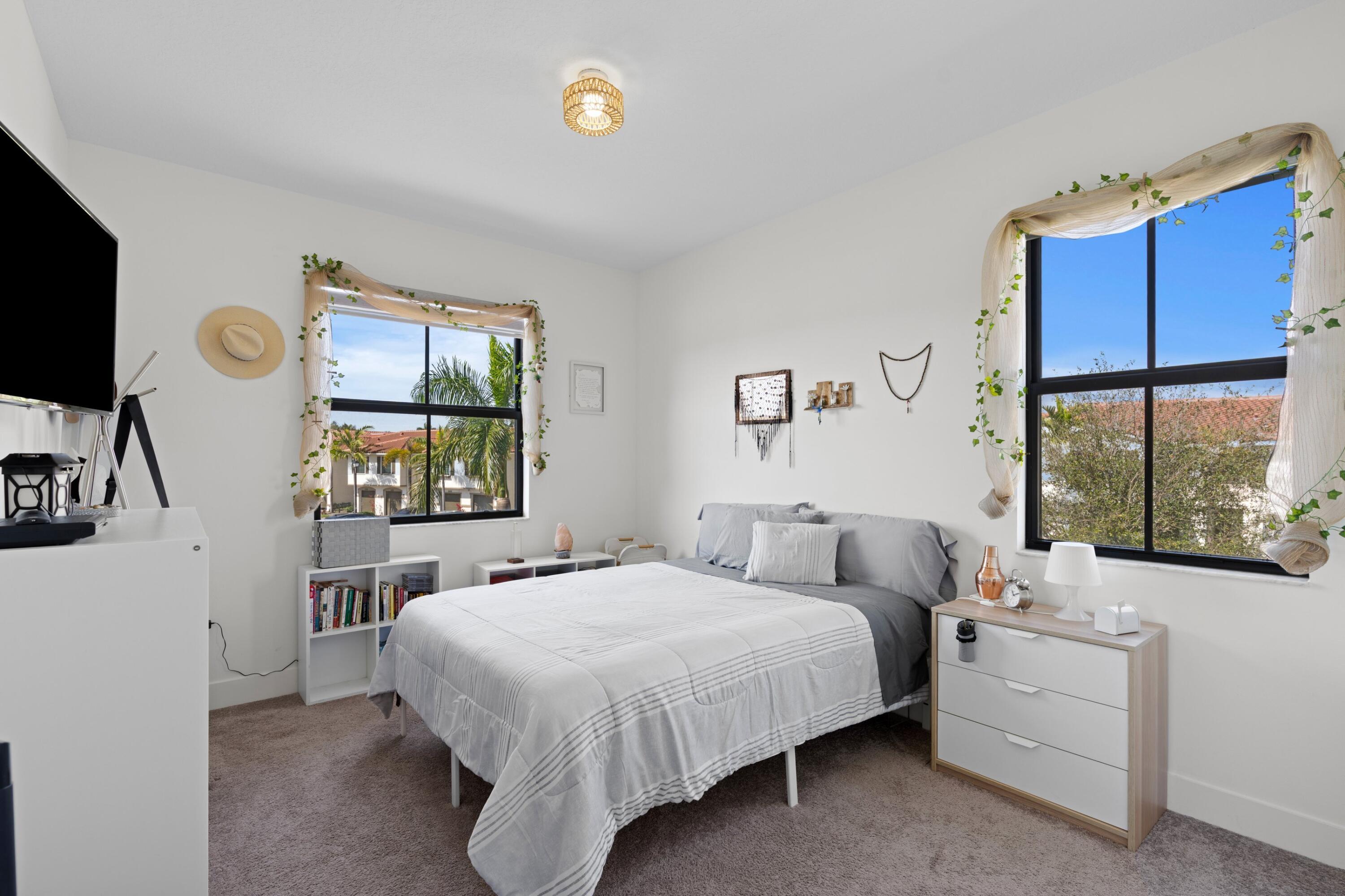 4021 Sycamore Cove Riviera Beach, FL 33410 - Photo 26 of 37 a bedroom with a bed and a flat tv screen on dresser