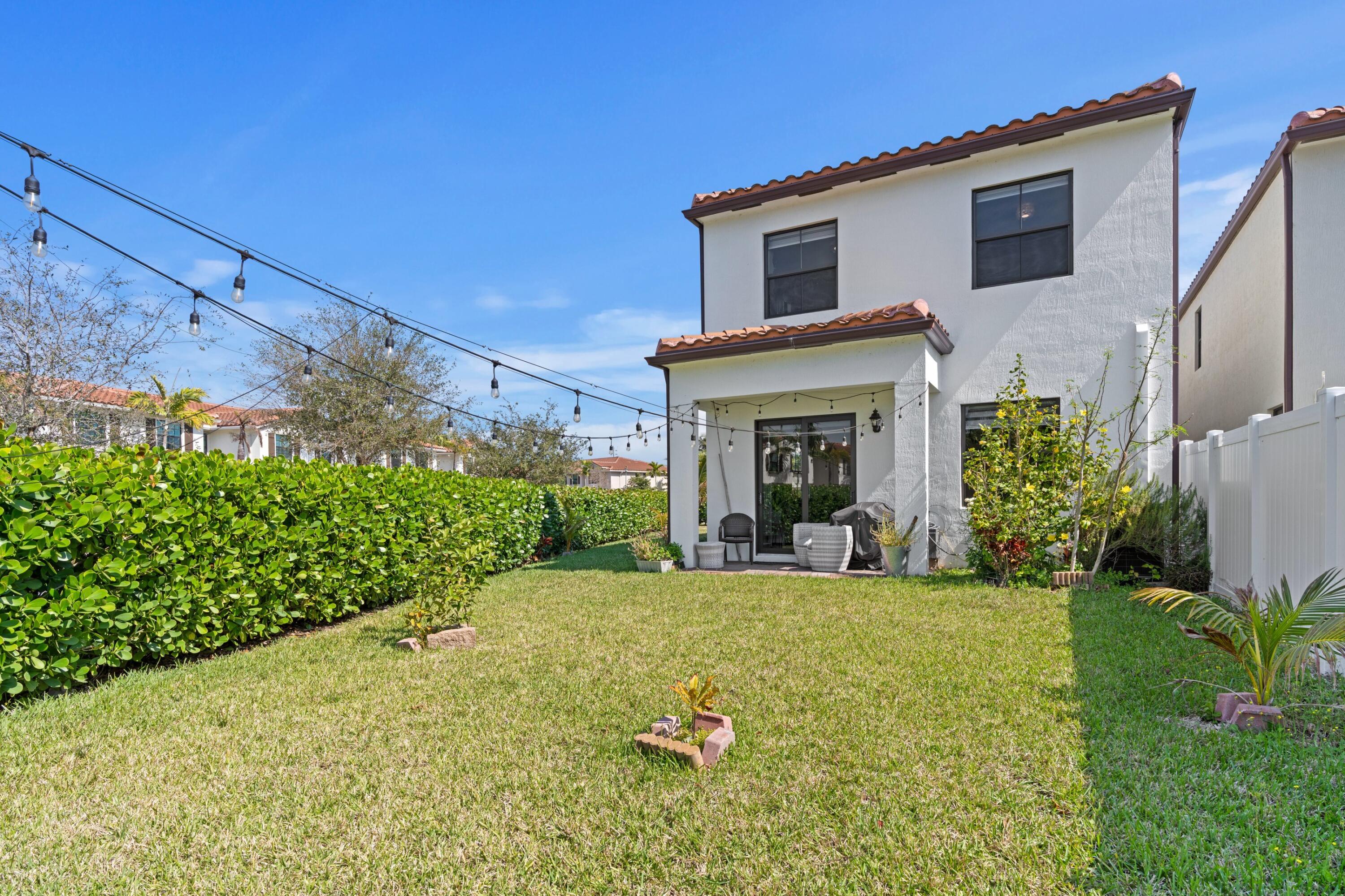 4021 Sycamore Cove Riviera Beach, FL 33410 - Photo 29 of 37 a view of a house with a yard