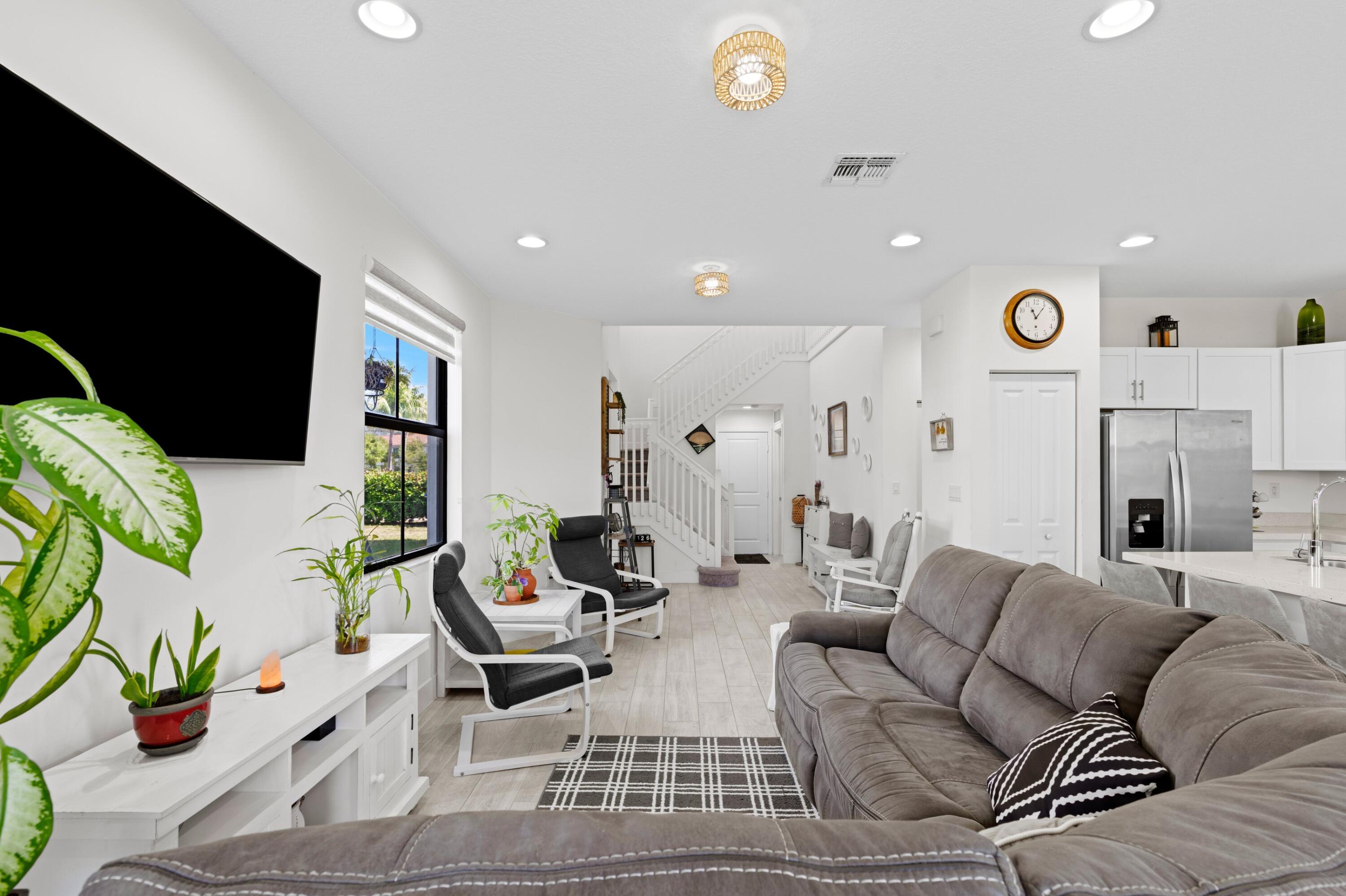 4021 Sycamore Cove Riviera Beach, FL 33410 - Photo 9 of 37 a living room with furniture a fireplace and a flat screen tv
