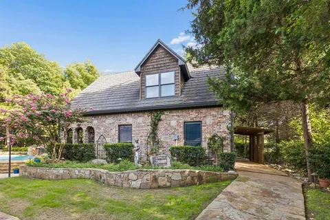 a front view of a house with garden and sitting area