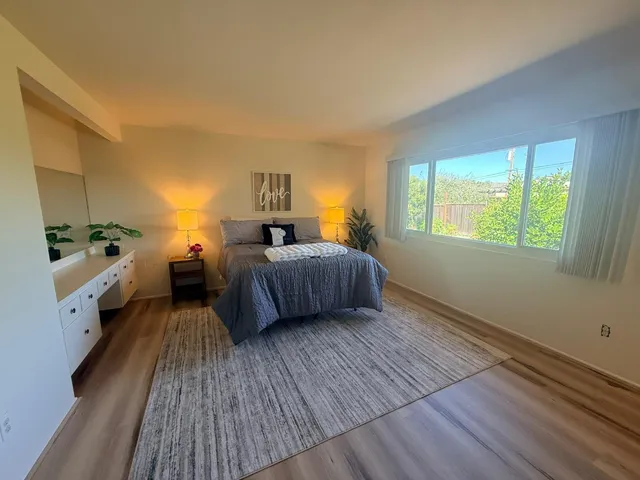 a bedroom with furniture and a large window