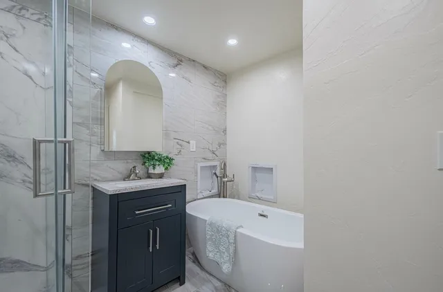 a bathroom with a granite countertop sink a toilet and shower