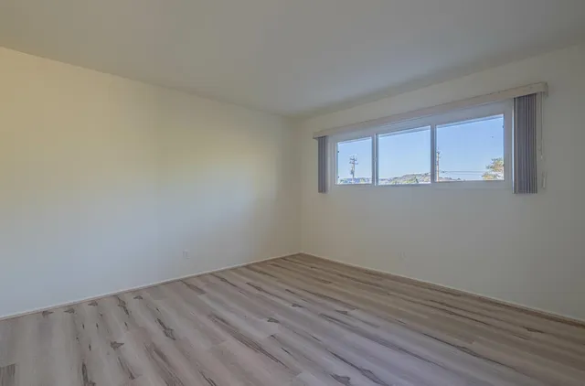 a view of a room that has wooden floor and window