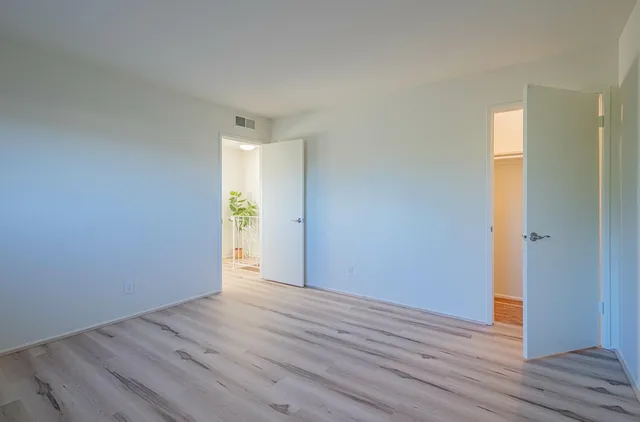 a view of an empty room with wooden floor
