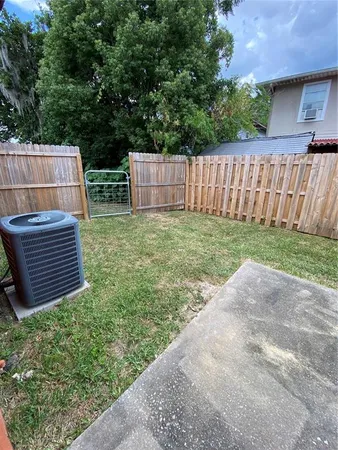 a view of backyard with wooden fence