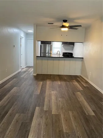 a view of a kitchen with wooden floor and a sink