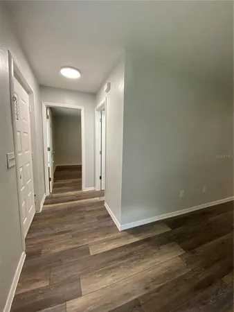 a view of a hallway with wooden floor and closet