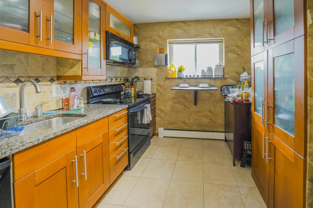 a view of a kitchen with stainless steel appliances granite countertop a stove a sink and a microwave
