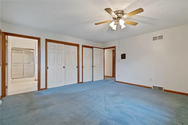 a view of an empty room with a ceiling fan