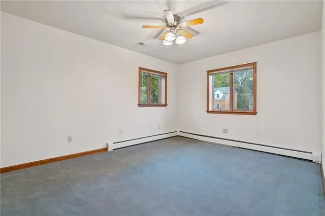 an empty room with a window and a fan
