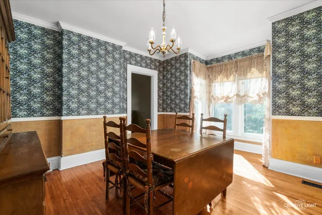 a kitchen with stainless steel appliances granite countertop a refrigerator a sink dishwasher a stove and a dining table with wooden floor