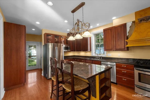 a kitchen with stainless steel appliances granite countertop a stove and a wooden floors