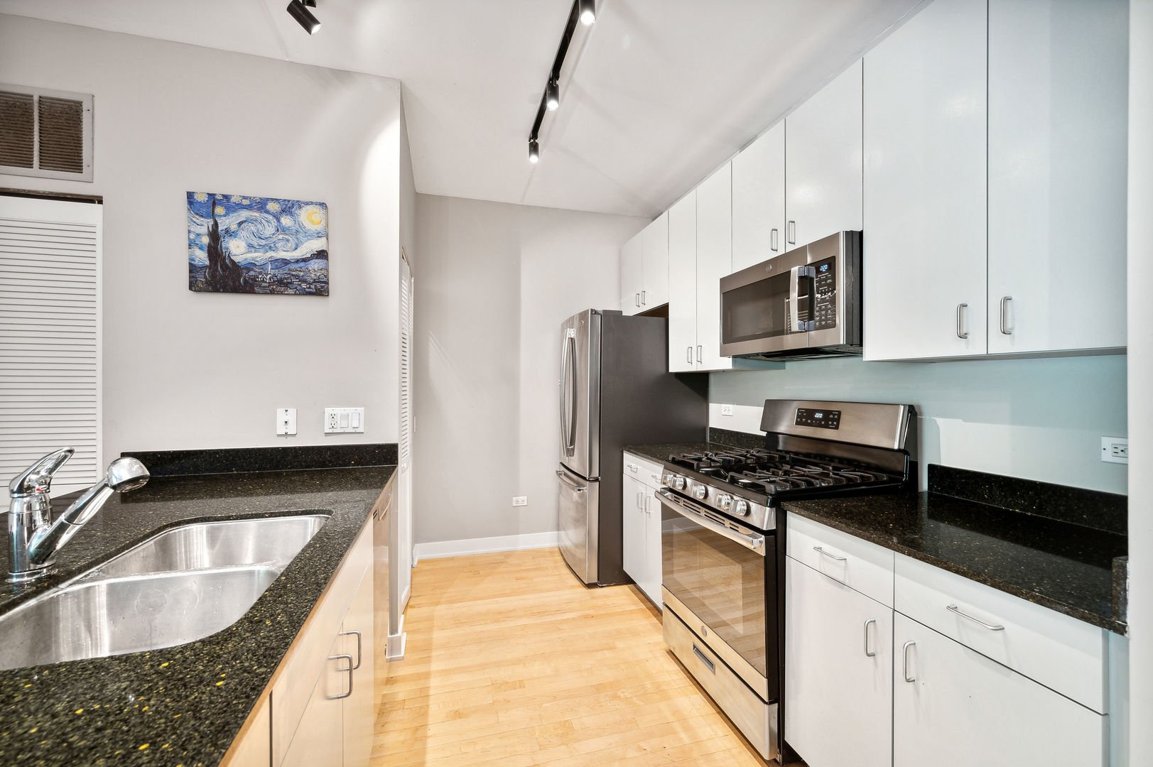 4311 North Sheridan Road, Unit 303 Chicago, IL 60613 - Photo 6 of 17 a kitchen with granite countertop a sink stainless steel appliances and cabinets