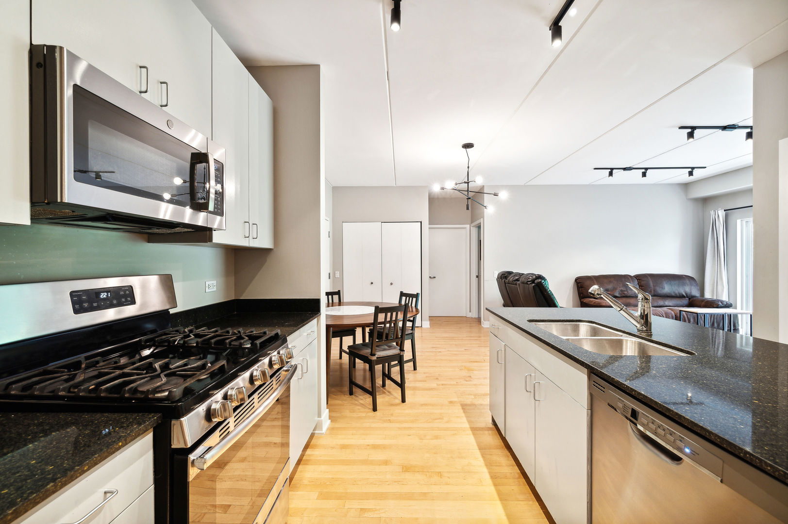 4311 North Sheridan Road, Unit 303 Chicago, IL 60613 - Photo 7 of 17 a kitchen with a stove a sink and a microwave