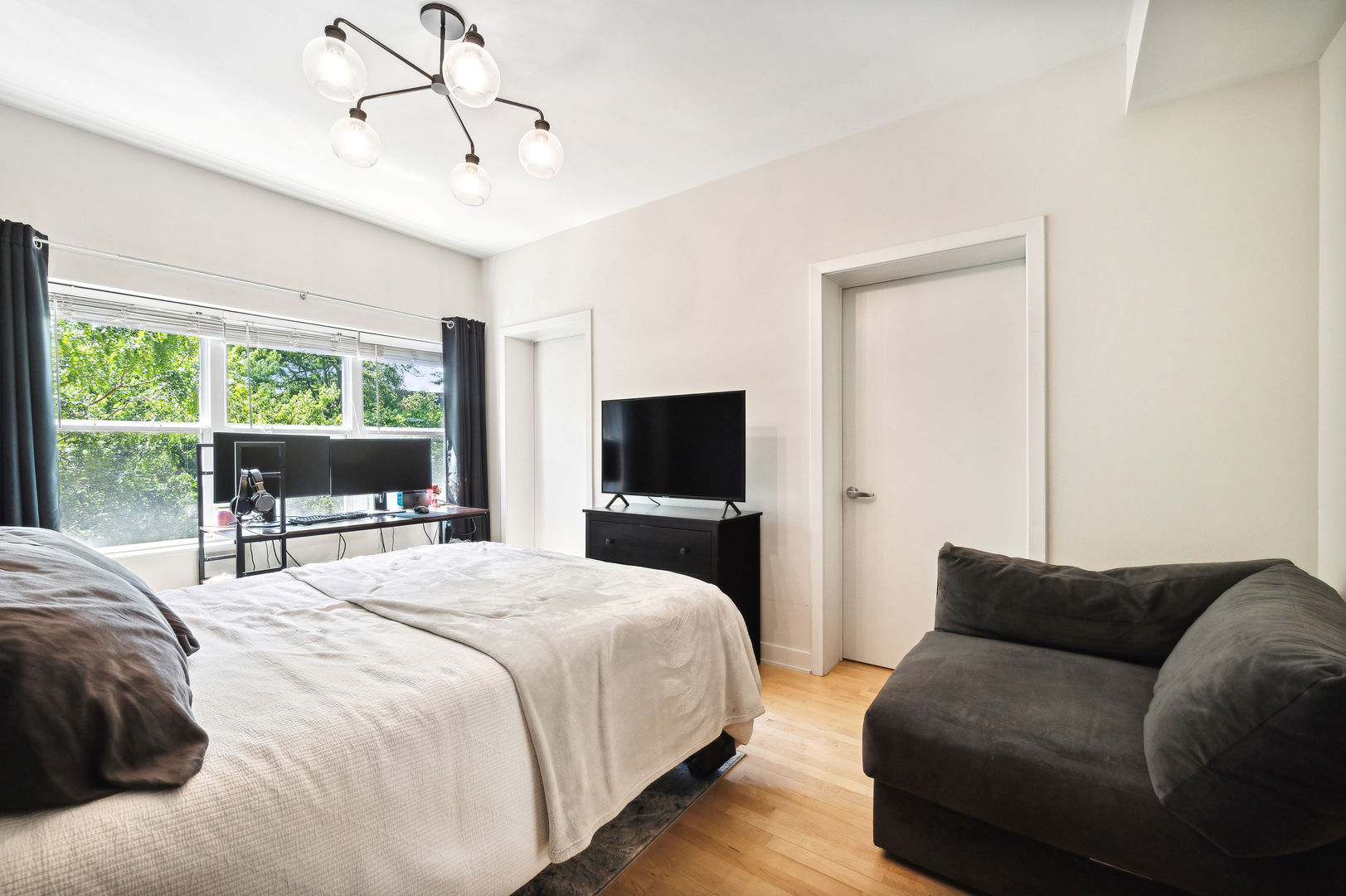 4311 North Sheridan Road, Unit 303 Chicago, IL 60613 - Photo 9 of 17 a bedroom with a bed a couch and large window