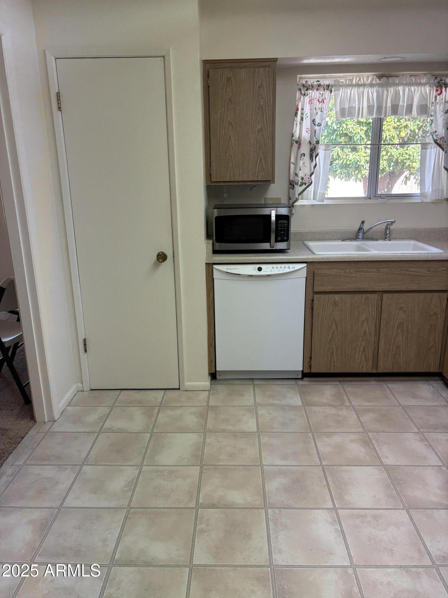 10326 West Pleasant Valley Road Sun City, AZ 85351 - Photo 3 of 8 a kitchen with a stove a sink and a microwave