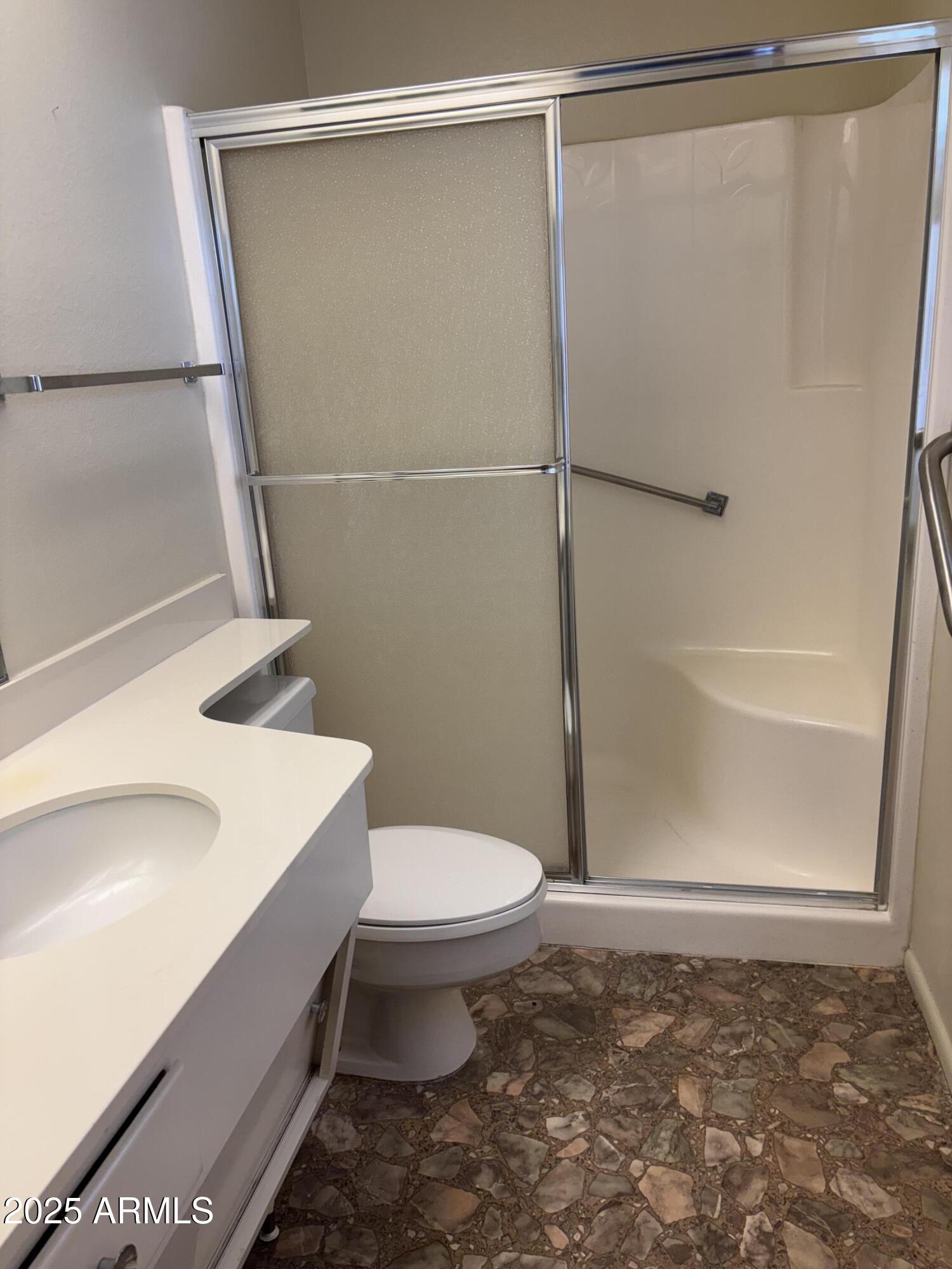 10326 West Pleasant Valley Road Sun City, AZ 85351 - Photo 7 of 8 a bathroom with a sink a toilet and shower