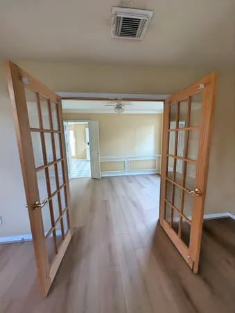 a view of an empty room with wooden floor and staircase