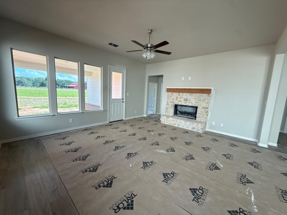 1228 Colca Drive Springtown, TX 76082 - Photo 4 of 9 Spacious living area featuring a floor-to-ceiling stone fireplace with a wood mantel