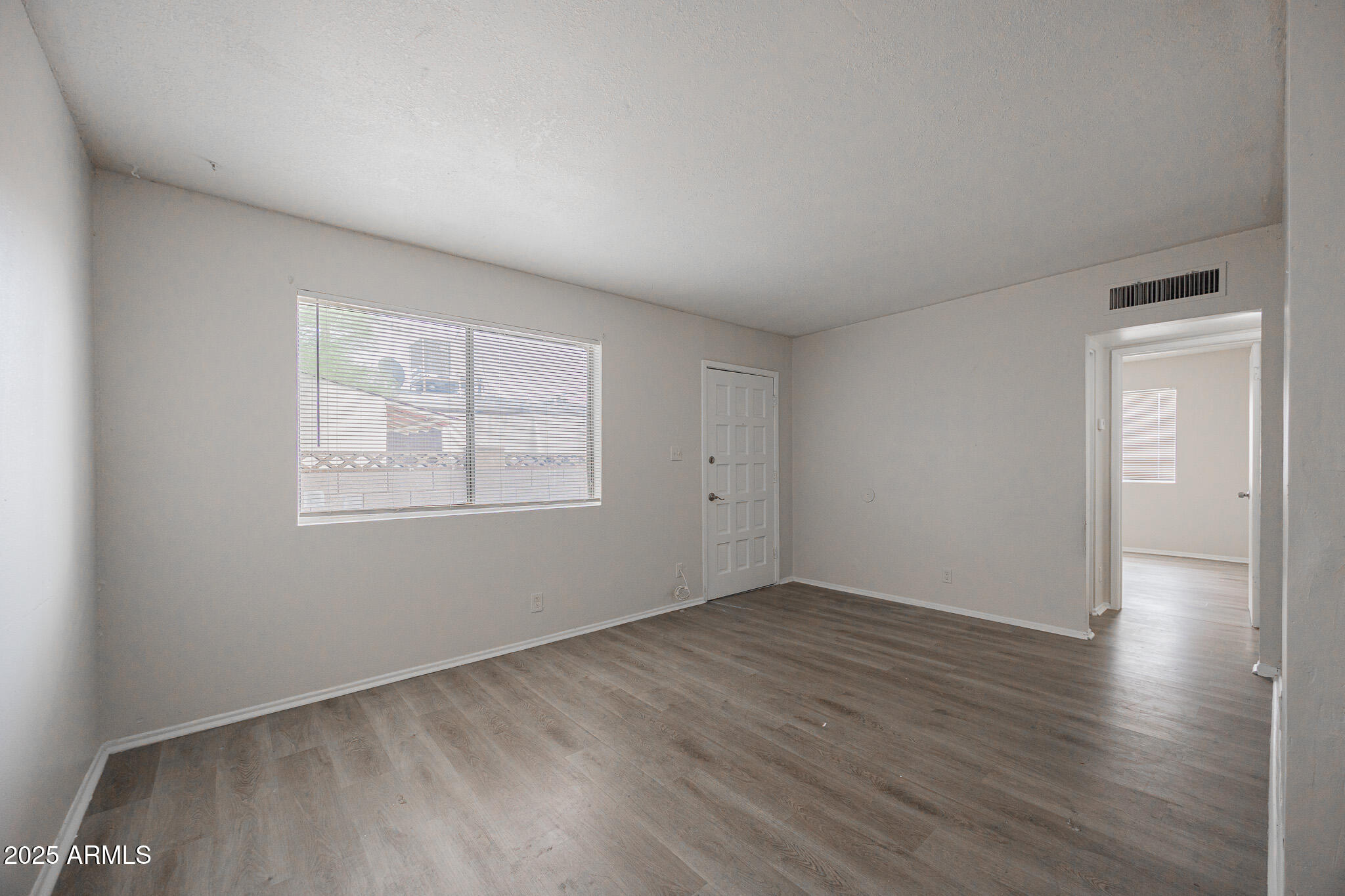2352 East Broadway Road, Unit A Mesa, AZ 85204 - Photo 4 of 14 an empty room with wooden floor and windows