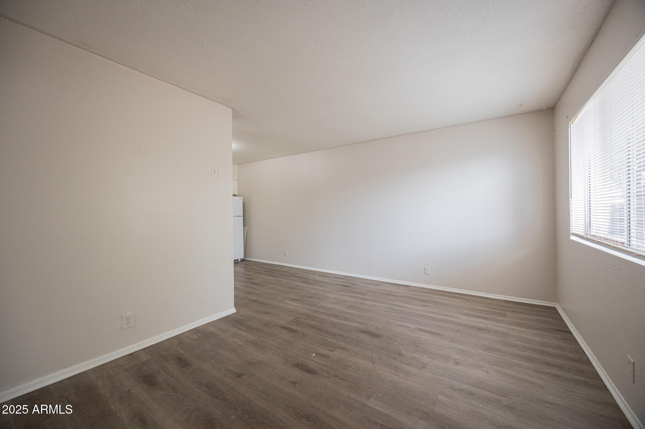2352 East Broadway Road, Unit A Mesa, AZ 85204 - Photo 6 of 14 an empty room with wooden floor and windows