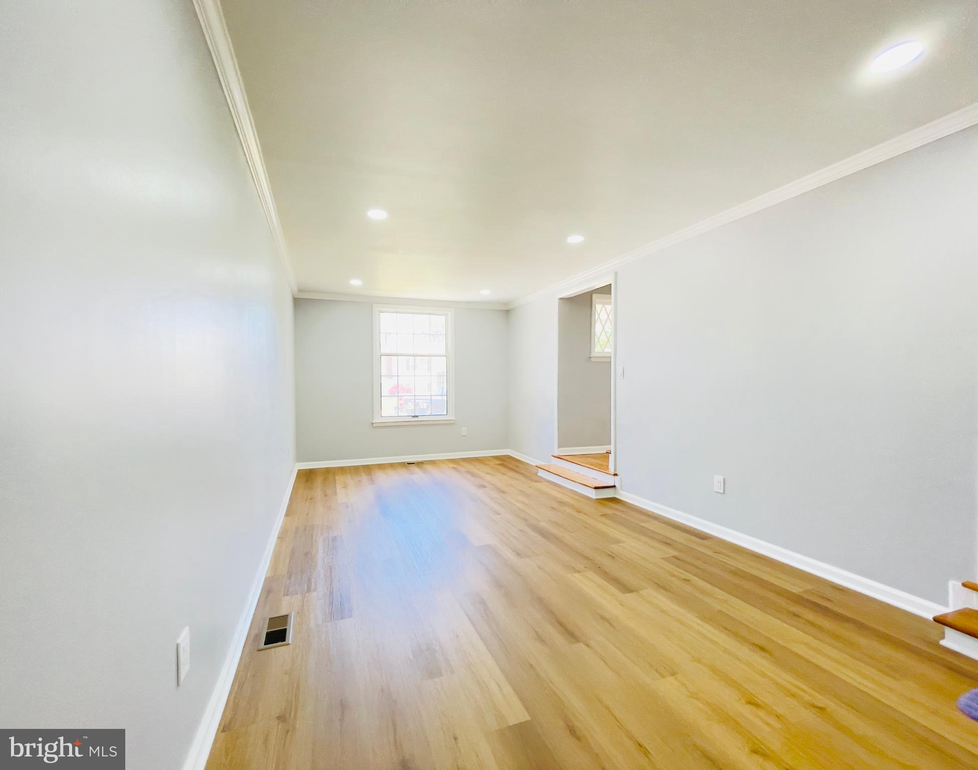 54 Saratoga Road Stratford, NJ 08084 - Photo 12 of 34 an empty room with wooden floor and windows