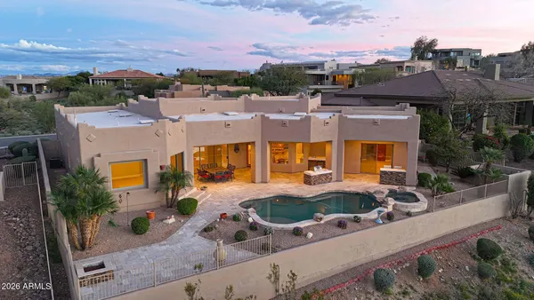 an aerial view of a house with swimming pool and furniture