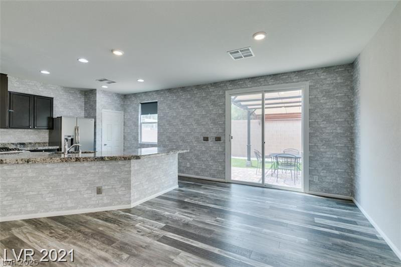 5475 Ordesa Valley Road Las Vegas, NV 89148 - Photo 28 of 35 A well-lit kitchen with sleek countertops and rich cabinetry, complemented by a vibrant wood floor.