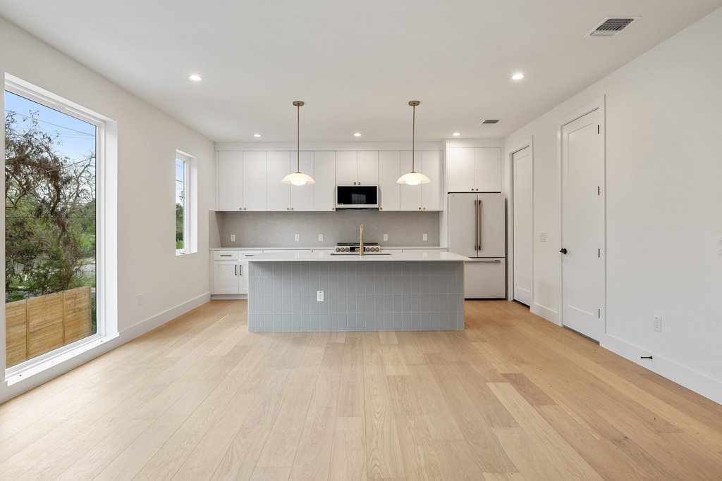 A well-lit kitchen with modern appliances and light wood flooring.