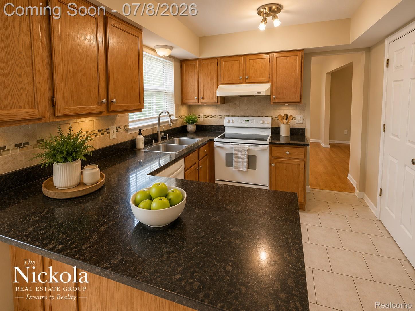 414 Whitney Drive Rochester, MI 48307 - Photo 14 of 30 Kitchen featuring wood cabinetry, dark countertops, a tile backsplash with mosaic accents, a double-basin stainless steel sink, and light-toned tile flooring