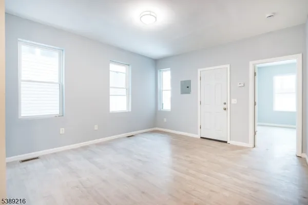 an empty room with windows and closet