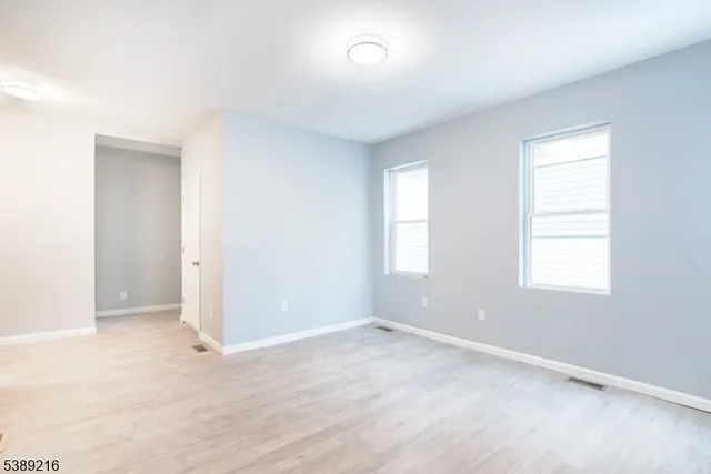 an empty room with windows and closet